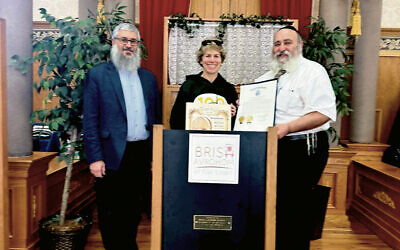 Rabbi Mendel Zaltzman, left, with Assemblywoman Lisa Swain (Dist. 38) and Rabbi Mordechai Kanelsky, holding the proclamation signed by the NJ Senate and Assembly.
