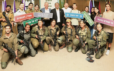 Young olim and IDF soldiers surround, back row center, from left, Yaron Shavit, deputy chair of the Jewish Agency for Israel and minister of aliyah and integration; MK Ofir Sofer; and Rabbi Yehoshua Fass, Nefesh B’Nefesh co-founder and executive director. Rabbi Fass used to live in Highland Park. (Yonit Schiller)