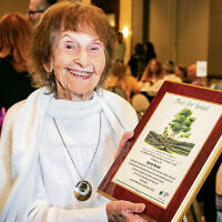 Janice Rosen, a longtime Jewish Standard employee, holds a plaque in honor of her husband Gerald, who died last year.