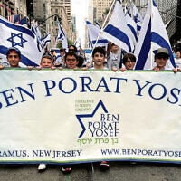 Ben Porat Yosef students hold flags as they walk uptown. Ben Porat Yosef students hold flags as they walk uptown.