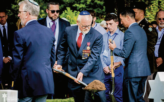Brigadier General Dirk Backen, secretary general of the German War Graves Commission, shovels dirt as Project Benjamin buries Nathan Baskind in the Normandy American Cemetery in 2024. (All photos courtesy Project Benjamin)