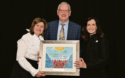 Diane, left, and Ron Strobel receive a work of art created by a Sinai student from Esther Lerer, Sinai vice president and a long-time member of its executive committee and board.