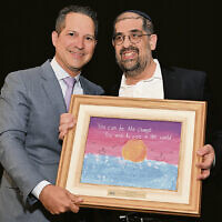 Honoree Yakov Karasick, right, receives a work of art created by a Sinai student from Moshe Weinberger, past president of Sinai and a long-time member of its executive committee and board. Honoree Yakov Karasick, right, receives a work of art created by a Sinai student from Moshe Weinberger, past president of Sinai and a long-time member of its executive committee and board.