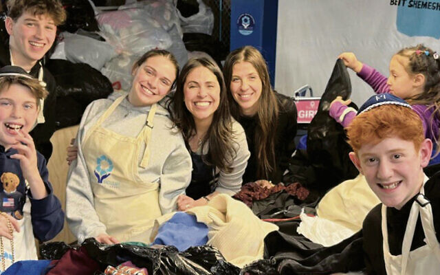 Lauren Turk of the Hangout, center, celebrates her store’s 5th anniversary by packing boxes of clothing for Israel with friends and family at Yad Leah.