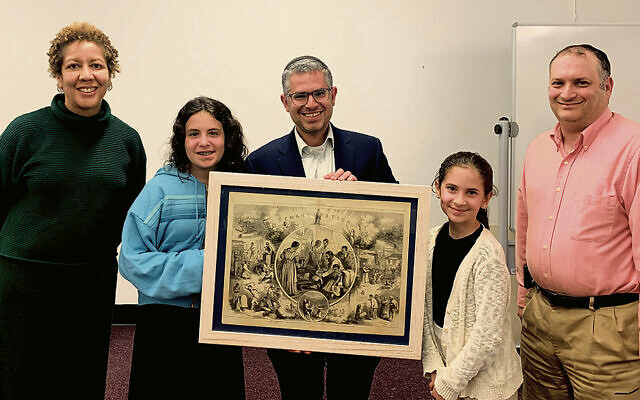 From left, Keisha Carter, Ella, Yigal, and Sara Gross, and Benjamin Burnat. Ms. Carter and Mr. Burnat are vice president and president, respectively, of the Teaneck library’s board of trustees. Mr. Gross holds the Nast drawing.