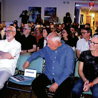 Attendees at the
art exhibition’s opening on May 18