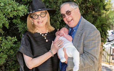 Gail and Jeremy Fingerman hold their newest grandchild, Avraham Chaim.