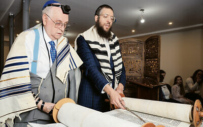 Roy Woods, 83, stands next to the Torah scroll and Rabbi Yisrael Bennish at Chabad of Bayonne.