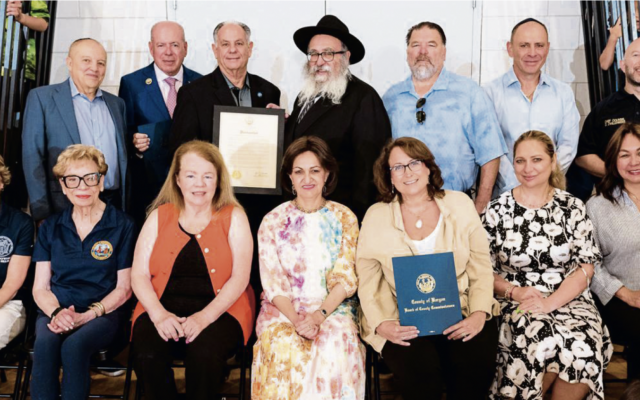 Seated, from left: Assemblywoman Lisa Swain (D-38), Commissioners Dr. Joan Voss and Mary Amororo, Bris Avrohom associate director Rebbetzin Shterney Kanelsky, Commissioner Tracy Silna Zur, sponsor Tanya German, and Commissioner Germaine Ortiz. Standing, from left: Bris Avrohom board member Mark Rekhtmen, Bergen County Clerk John Hogan, County Executive James Tedesco III, Bris Avrohom executive director Rabbi Mordechai Kanelsky, Commissioner Thomas Sullivan, sponsor Vlad German, and a representative from the sheriff’s office. (Courtesy Bris Avrohom)