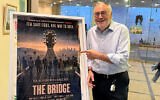David Fishof points at a poster for the new documentary, “The Bridge.” (All photos courtesy David Fishof)