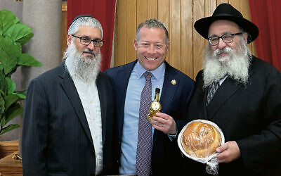 Rabbis Mendel Zaltzman and Mordechai Kanelsky gave Congressman Josh Gottheimer honey and a round challah for Rosh Hashanah. (Courtesy BA)