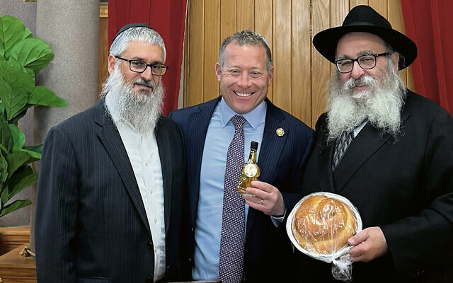 Rabbis Mendel Zaltzman and Mordechai Kanelsky gave Congressman Josh Gottheimer honey and a round challah for Rosh Hashanah. (Courtesy BA)