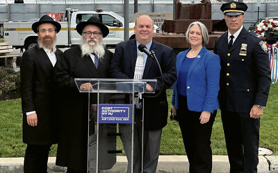 Rabbis Avremy Kanelsky and Mordechai Kanelsky, left, with Frank Radics, manager of physical plant and redevelopment for the New Jersey airports at Port Authority of New York & New Jersey; Sarah McKeon, director of the Port Authority’s aviation department; and Michael Belcher, deputy inspector of the PATH Command for the Port Authority police department. (Courtesy Bris Avrohom)