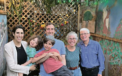 Young parents Rebecca and Marvin, with their kids, Jacob and Liora, visit with Merrill and Andy as the sukkah goes from family to family.
