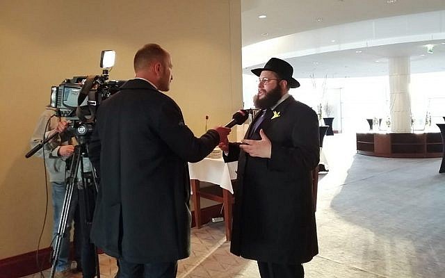 Rabbi Shalom Ber Stambler speaks to the Polish media ahead of sundown at the Warsaw Hilton, April 19, 2019. Hundreds gathered to celebrate the first seder in the former Warsaw Ghetto since it was razed in 1943. (Courtesy Chabad of Warsaw/via Times of Israel)