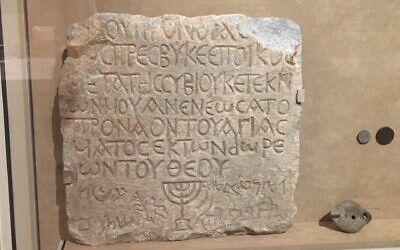 A marble plaque recording a donation to a Roman synagogue is in The Metropolitan Museum of Art, next to the staircase which is lined with the the names of the people who gave donations to the museum. (Jewish Week)