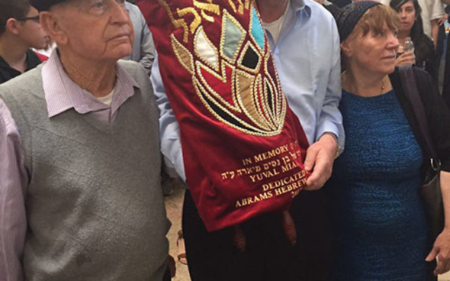 Rabbi Ira Budow, director of Abrams Hebrew Academy, is flanked by Nissim and Susan Miara, parents of Yuval, at the Torah dedication ceremony in Jerusalem.