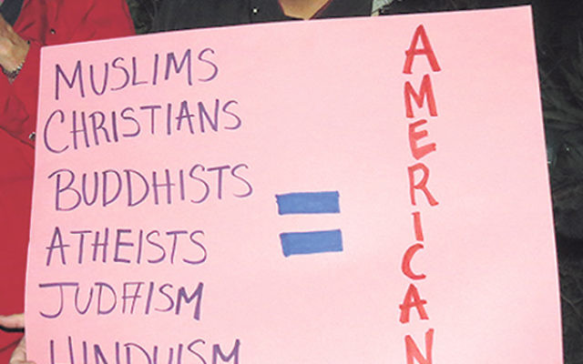 A woman holds a sign urging equality for all Americans.