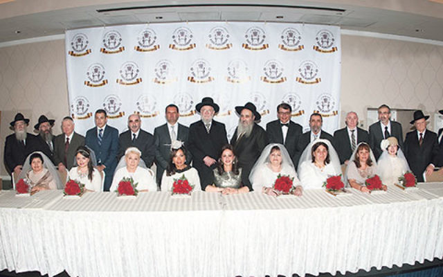 Rabbi Yisroel Meir Lau, Rabbi Mordechai Kanelsky, Shterney Kanelsky, and leaders of Bris Avrohom celebrate with the eight couples married on Sept. 14.    