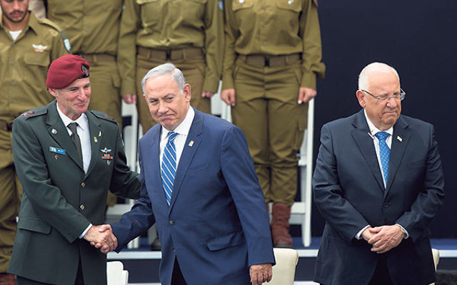 Prime Minister Benjamin Netanyahu, center, shaking hands with Deputy IDF Chief of Staff Yair Golan, and standing with President Reuven Rivlin, at an Israeli Independence Day ceremony honoring soldiers, May 12.     