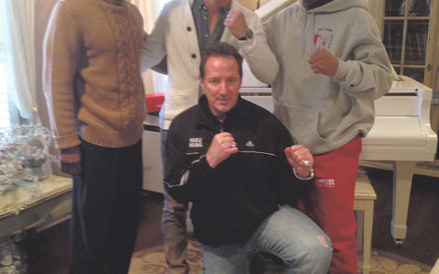 Dustin Fleischer, standing, center, with his father, Phil, kneeling; his trainer, Jamal Abdullah, left; and his martial arts instructor, John Gaddy.     