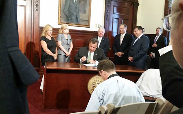 NJ Gov. Chris Christie, at a State House ceremony in Trenton, signing a bill prohibiting the state’s pension and annuity funds from investing in companies that boycott Israel or Israeli businesses, Aug. 16, 2016. (Josh Pruzansky)