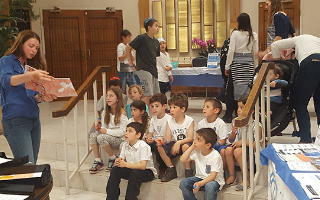 Lior Ben-Zvi reads to youngsters as part of the children’s program. Photo COURTESY Jewish Federation in the Heart of NJ