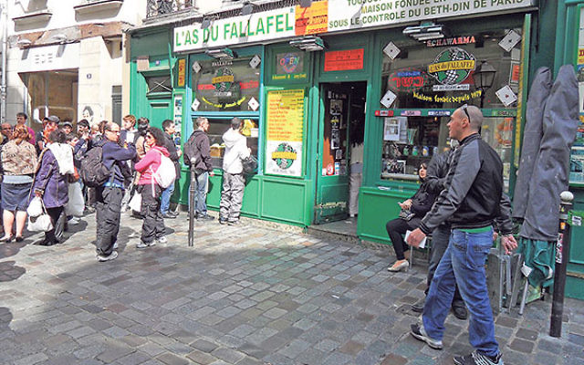 Yomi Peretz, right, approaching a line of tourists waiting to place their orders at L’As Du Fallafel in the historic Jewish quarter of Paris, April 2012.      