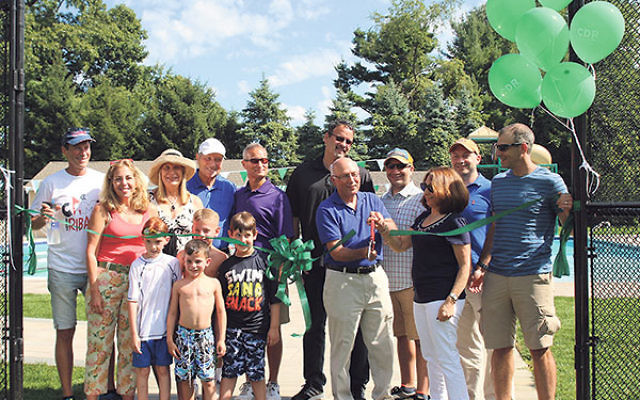 At the dedication of the Flo Peck Pool at Camp Deeny Riback are campers Ryan Strulson, front, and, from left, Seth Perlstein (grandson of the Seidens), Noah Stoch, and Tyler Feldman; and, from left, Mitchell, Valerie, Cindy, Martin, and Norman Riback; Fla