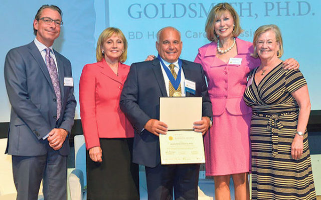 The Jewish Renaissance Medical Center Foundation’s Alan Goldsmith, center, displays his Jefferson Award during a ceremony at the Newark Museum; with him are, from left, New Jersey Advance Media president Matt Kraner, Lt. Gov. Kim Guadagno, PNC Bank