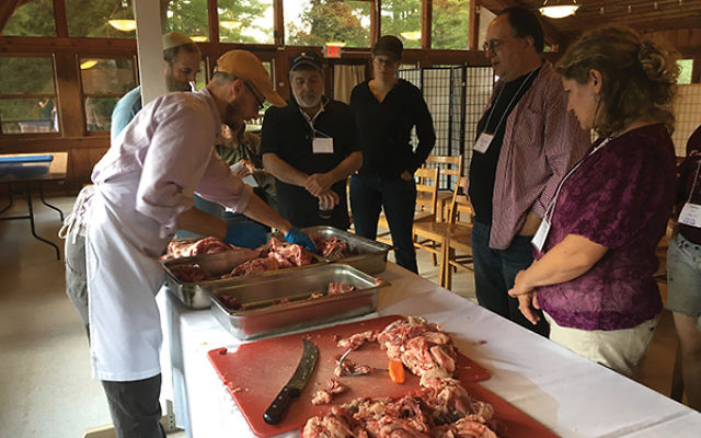 Ian Herztark de-bones and trims a beef chuck to be served at the food conference that took place Aug. 9-13.