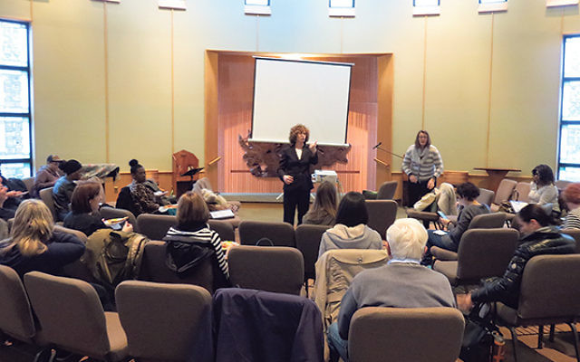 Suzanne Groisser, coordinator of legal services at the Rachel Coalition, left, and Sara Mendez Emma, clinical coordinator of child and adolescent services at Jewish Family Service of MetroWest, instruct a class of volunteers training to become members of
