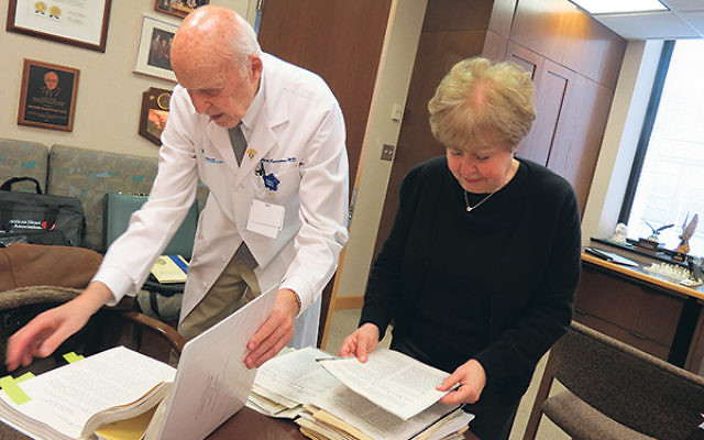 Surgeon Victor Parsonnet and Linda Forgosh, executive director of the Jewish Historical Society of New Jersey, examine some of the papers he is donating to JHS. 