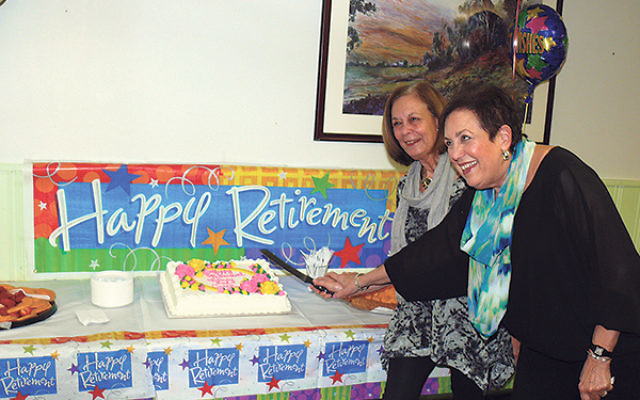 Outgoing co-executive directors of JVS Caren Ford, left, and Nancy Fisher cut the cake at their retirement party in mid-March.     