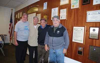 Post 972 leaders, from left, Jack Small, Tom Renna, Bernie Rothenberg, and Bob Schwartz, in front of the post’s Wall of Honor in the JWV room at Marlboro Jewish Center. Photo by Alan Richman