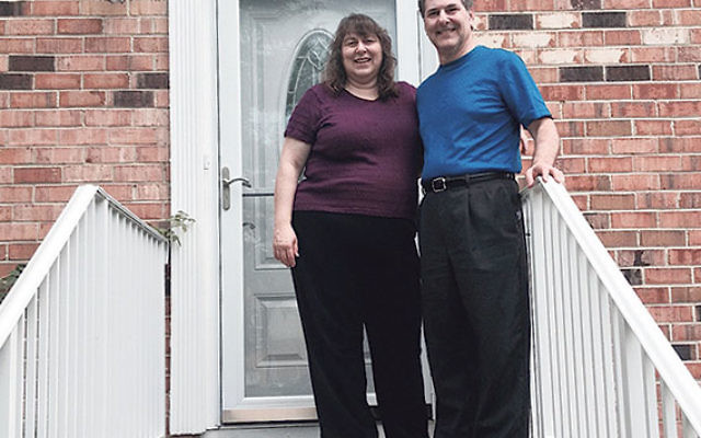 Evette and Art Katlin in front of their rebuilt house after a fire devastated it in 2012.