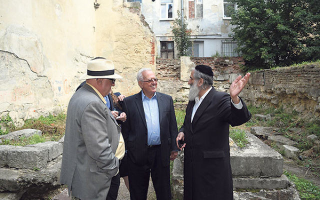 Meylach Schochet, a leader of the Jewish community in Lviv, right, stands beside Larry Lerner, center, and Rutgers University professor Stephen Bronner in the ruins of the Golden Rose Synagogue, which Schochet hopes to rebuild. 