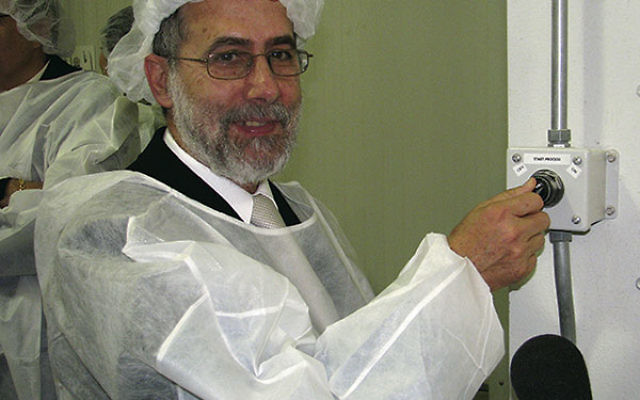 Rabbi Menachem Genack, CEO of the Orthodox Union’s Kashrus Division, pressed a button to launch the first batch of kosher-for-Passover shmura matza in March 2010 at the Manischewitz company’s new factory in Newark.     