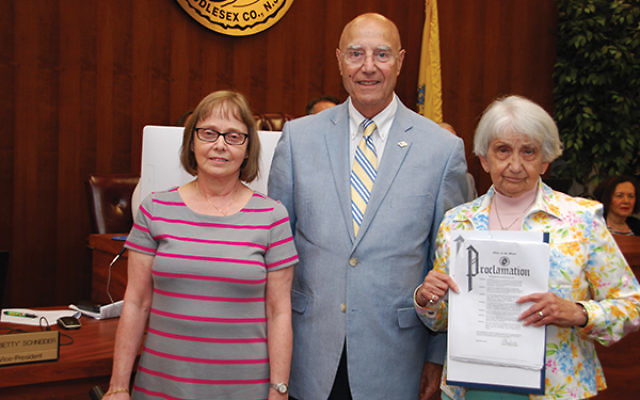 Monroe Township Mayor Gerald Tamburro is flanked by Karen Mandel, on left, and Marilyn Gerstein, who is holding the proclamation condemning anti-Semitism. Photo by Alan Richman
