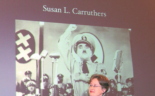 Susan Carruthers, a professor of history at Rutgers-Newark, seated below a poster for The Great Dictator, Charlie Chaplin’s satirical 1940 film portrait of Adolf Hitler. Carruthers said the Production Code, which laid out strict regulations