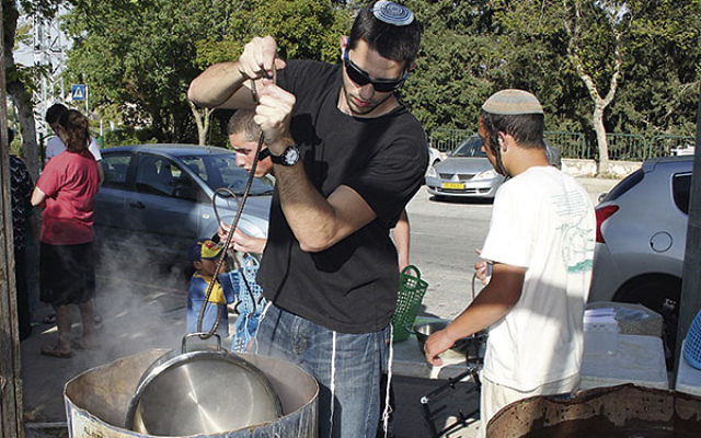 Residents get their cooking pots dipped into hot water in preparation for Passover in Efrat, a Jewish settlement in the West Bank.        
