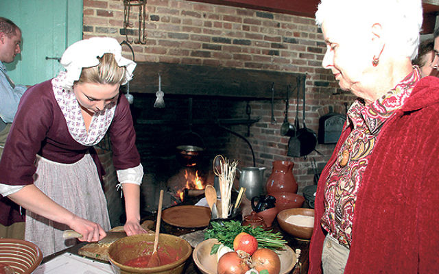 Chef Sarah L. chops onions to make albondigas, a Sephardi meatball recipe, as Leila Sulkes of Freehold looks on.