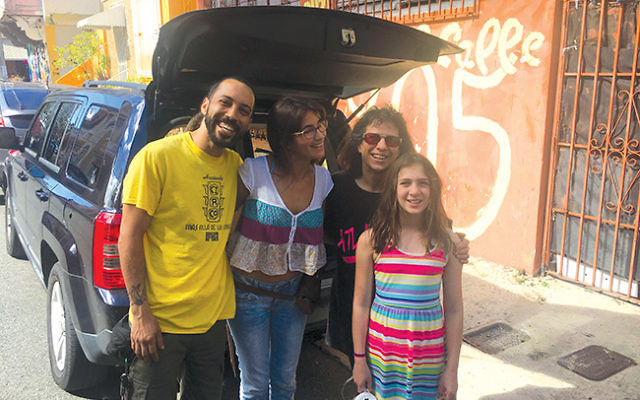 Julie Meyers, at right, with Dylan Meyers, and staff members of the Social Circus of Puerto Rico in front of an open trunk loaded with donated items collected in New Jersey. Photo by Karin Meyers