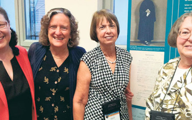 Rabbi Sally Priesand, right, with other pioneering rabbis, from left, Jacqueline Tabick, Amy Eilberg, and Sandy Eisenberg Sasso, with a photo of Rabbi Regina Jonas at Centrum Judaicum Archive in Berlin, July 22.