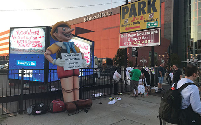 The StandWithUs protest included a 15-foot Pinocchio, and graffiti artists spray-painting T-shirts with messages of peace. Photo by Perry Bindelglass
