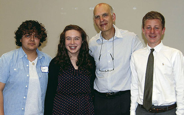 Michael Rubell, second from right, honors three students for their work on promoting Holocaust awareness, from left, Grace Gentle, Ella DeBode, and Harry Kern. 