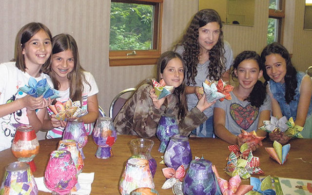 Youngsters at the TLC program of Camp Keshet at Young Israel of East Brunswick, with decorated vases and paper flowers to be given to seniors.     