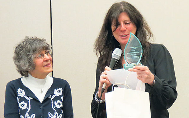 Melanie Roth Gorelick receives a trophy for her work with the NJ Coalition Against Human Trafficking; it was presented by Susan Neigher, left.     