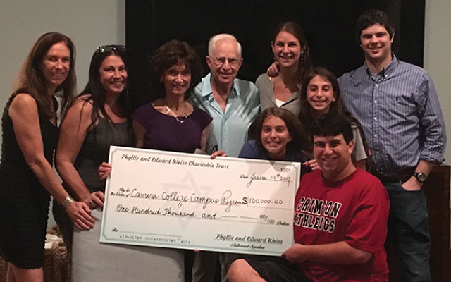 Phyllis and Edward Weiss and their children and grandchildren display a check representing their donation to CAMERA on Campus.