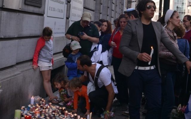 Adults and children participating in a silent vigil outside the Jewish Museum of Belgium in Brussels for the four victims of a shooting there by an unidentified gunman, May 25, 2014. (Cnaan Liphshiz)